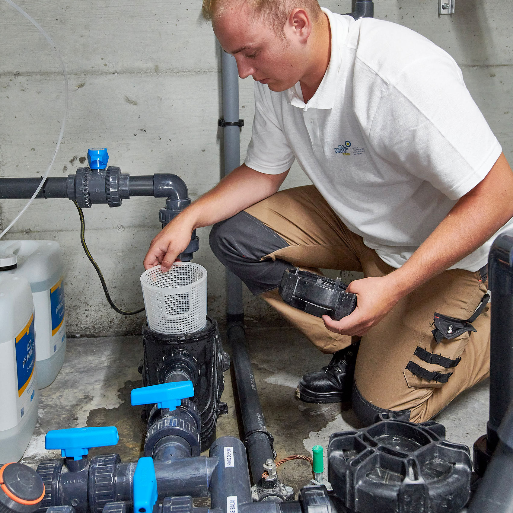 Plombier travaillant sur une pompe à eau dans une installation industrielle.